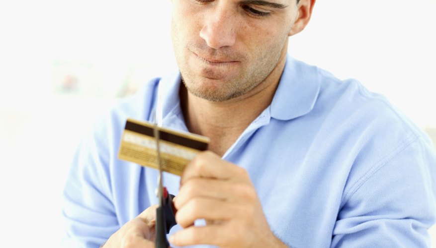 man cutting up a credit card